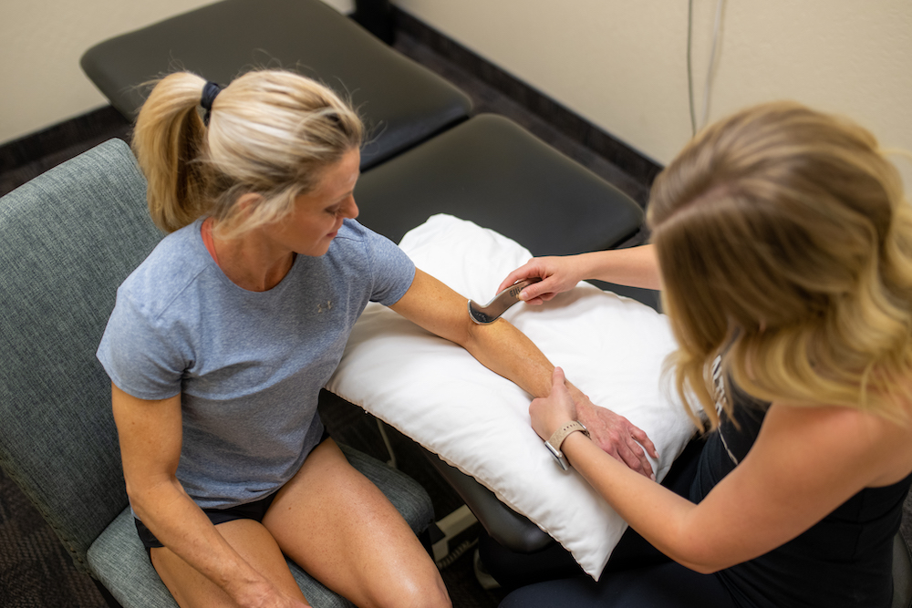 A woman is getting a massage from a physical therapist.