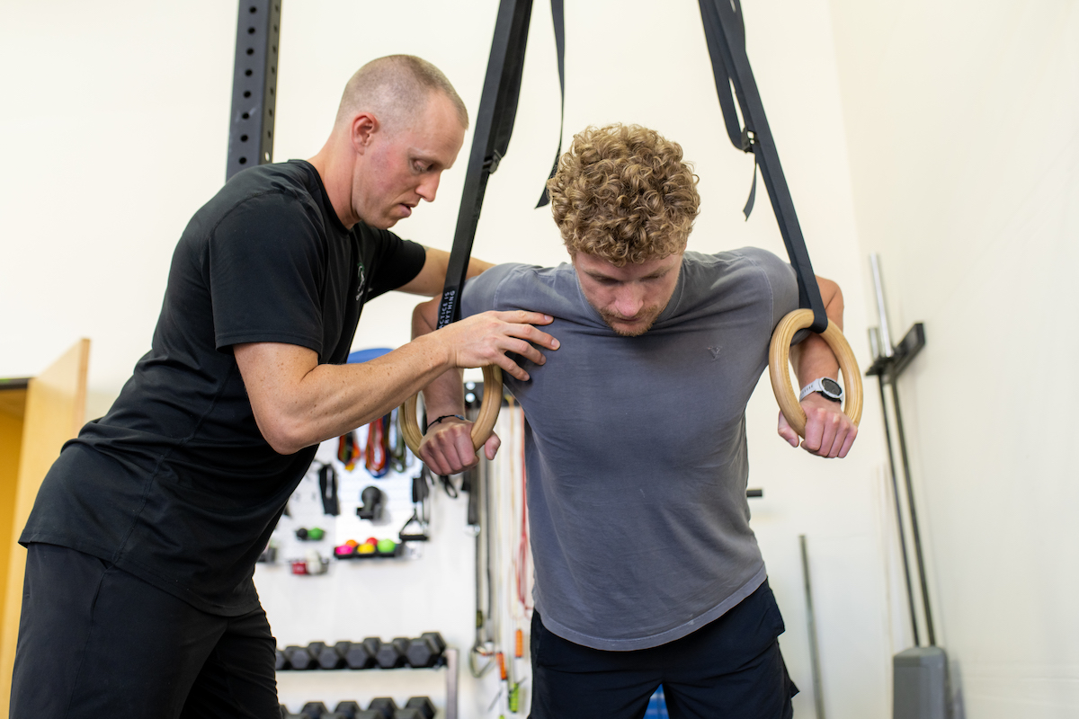 A man and a woman working out in a gym.