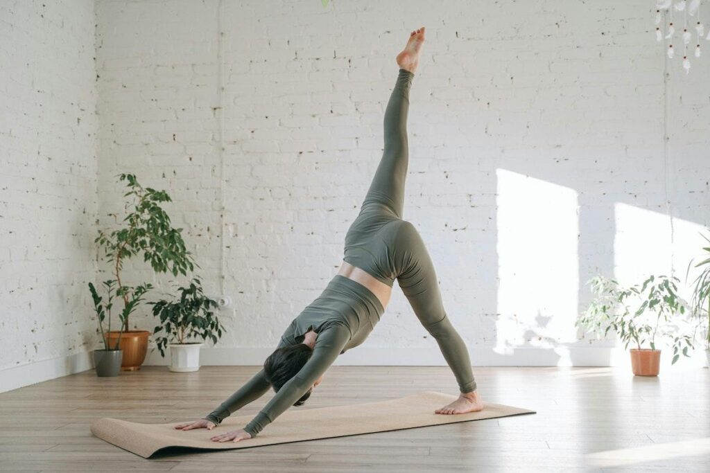 A woman doing a yoga pose on a mat.